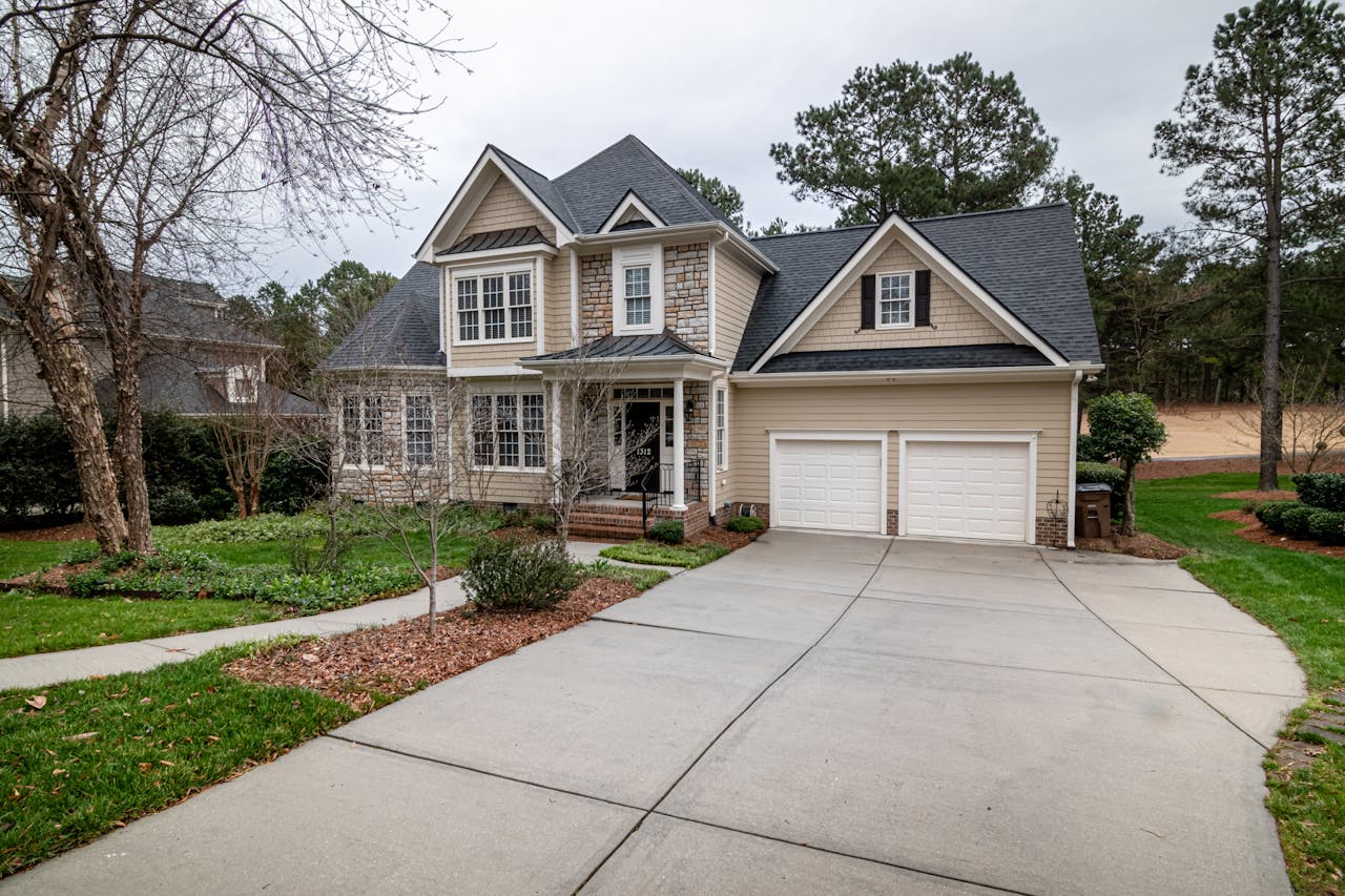 our-story Charming suburban home featuring a two-car garage, manicured lawn, and inviting entrance.