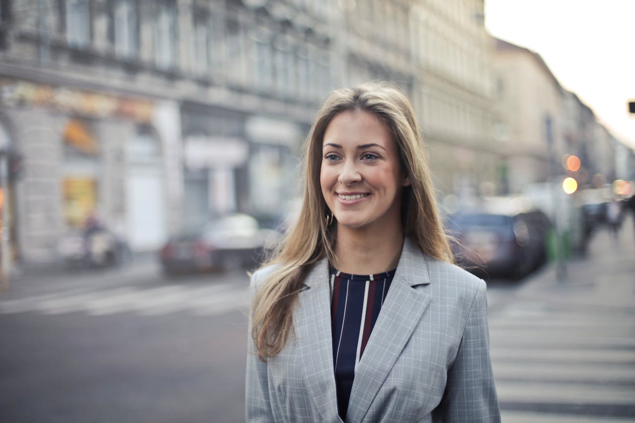 services-02 Confident businesswoman smiling outdoors in urban Budapest setting.