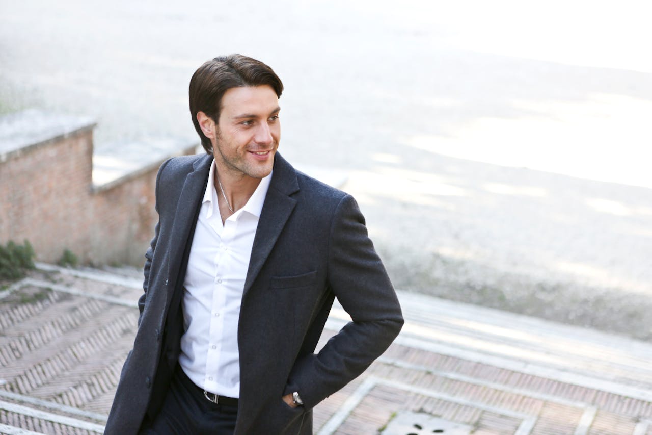 services-04 Confident man in a suit smiling while walking outdoors, showcasing fashion and style.